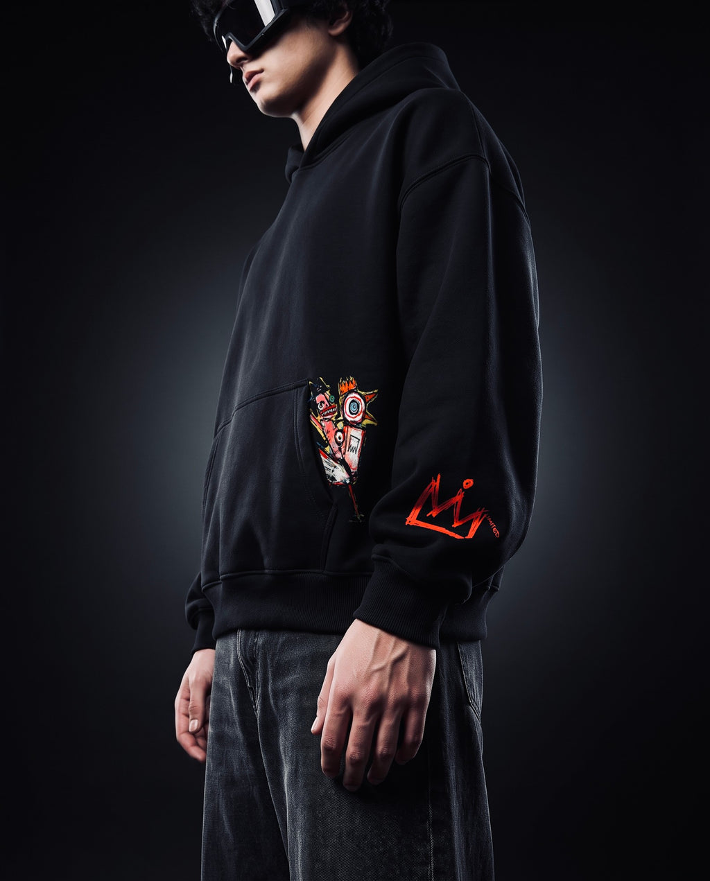 Model wearing X Edition If Not Now Then When black oversized hoodie, side view with pocket graphic and red crown sleeve
